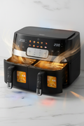 Black air fryer with open door showing interior on a light background